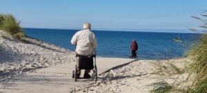 Best Ager mit Rollator am Strand von Wustrow