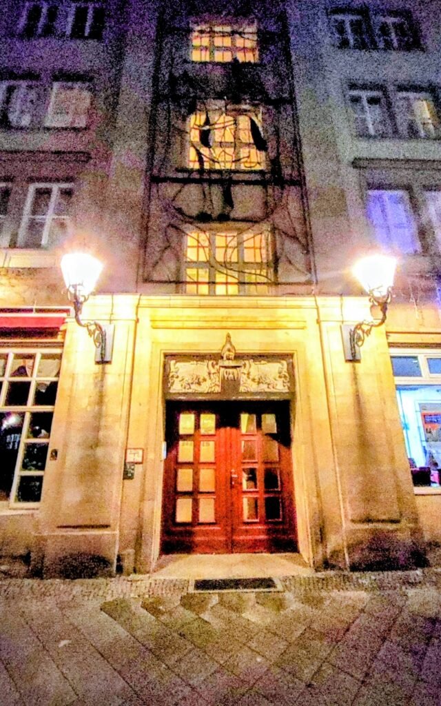 Beleuchteter Hauseingang mit Fassade darüber