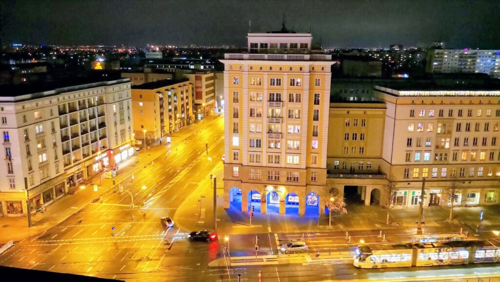 Kreuzung Otto-von-Guericke-Straße / Ernst-Reuter-Allee bei Nacht mit Wohngebäuden im "Zuckerbäckserstil"